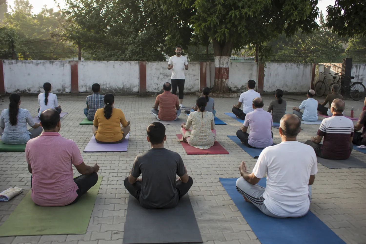 Illustration: an outdoor group yoga session on mats in a community courtyard